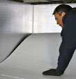 contractor installing TerraBlock™ floor insulation in a Clearfield crawl space