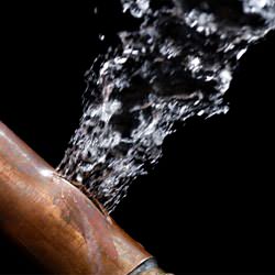 A bursting copper pipe in Saint Marys, with water gushing out.