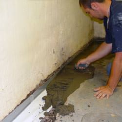 A basement waterproofer installing a perimeter drain system in Coudersport