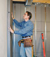 Insulated basement wall panels being placed against a concrete foundation wall in Punxsutawney